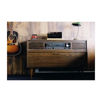 a wooden cabinet with an acoustic guitar and a radio