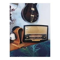 an old radio and a guitar on top of a shelf
