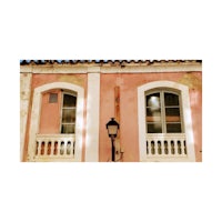 a pink building with a lamp on it
