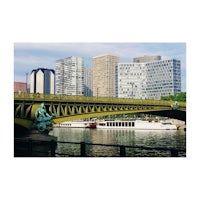 a bridge over a river with tall buildings in the background