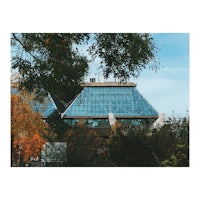 a glass building with trees in the background