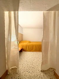 a bedroom with a yellow bed and yellow curtains