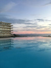 a swimming pool in front of a building at dusk